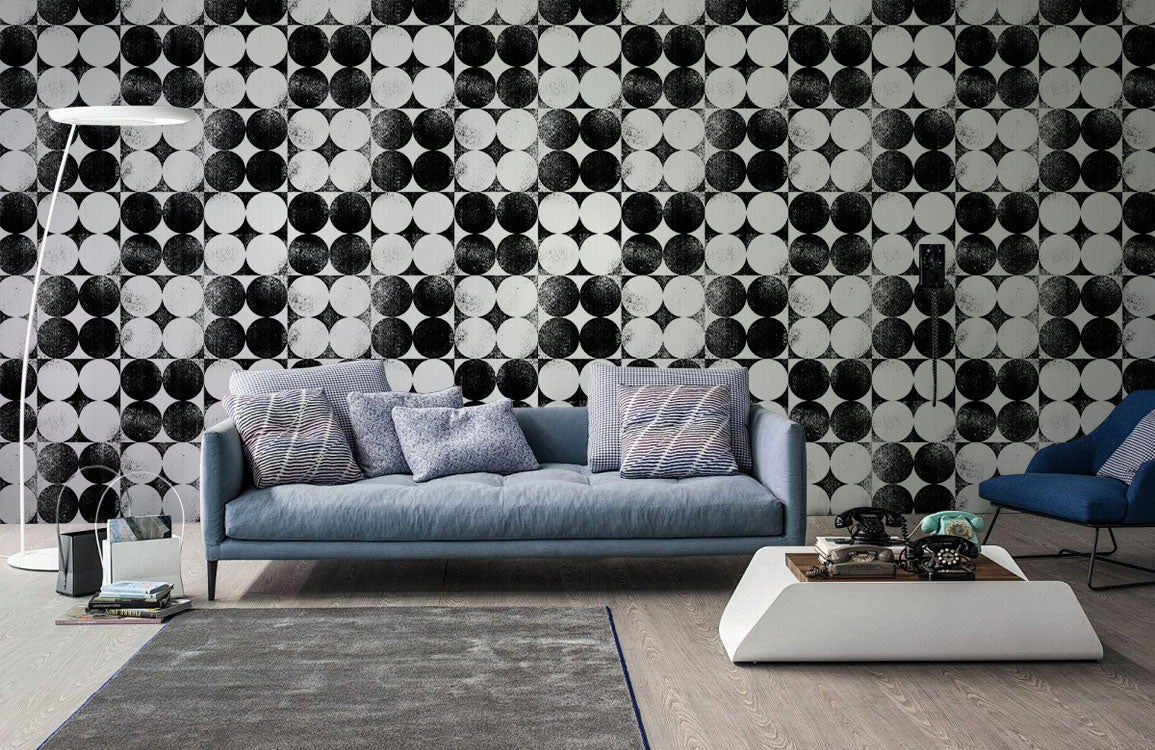 Monochrome Geometric Op Art Circles Wallpaper in living room with blue sofa and modern decor elements.